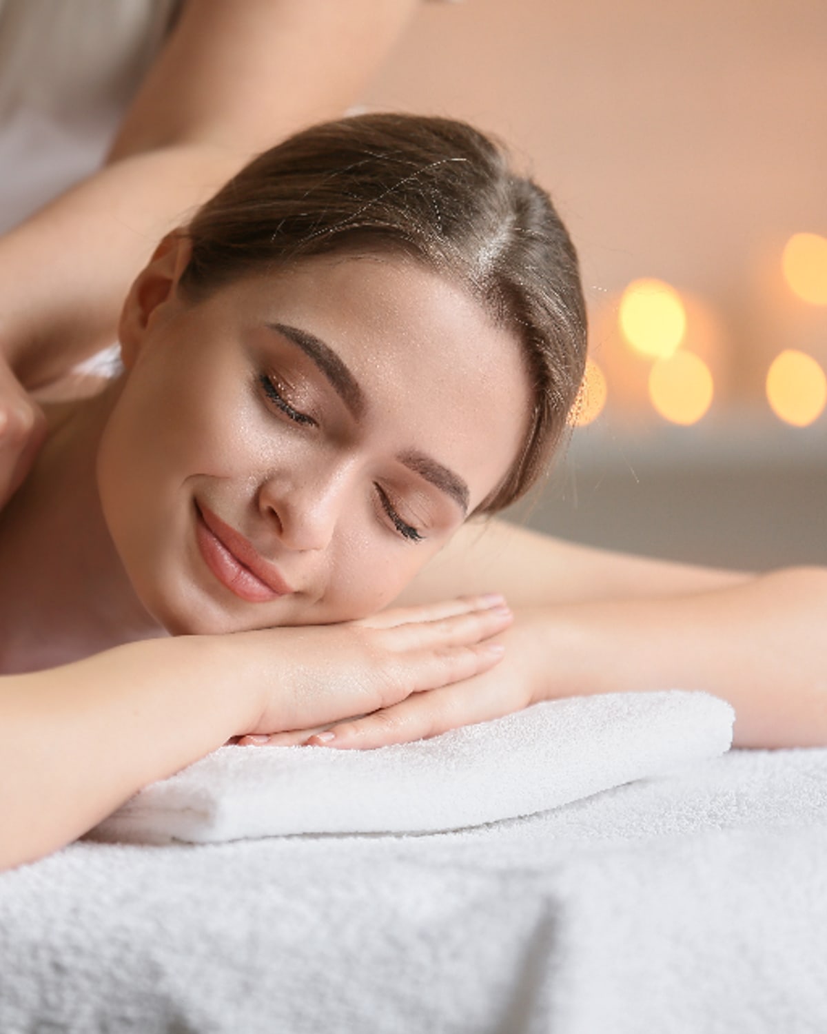 Woman using a gentle body scrub in a warm bathroom