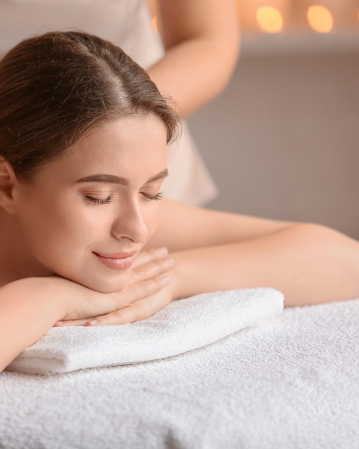 Woman applying moisturizer in a warm winter bathroom